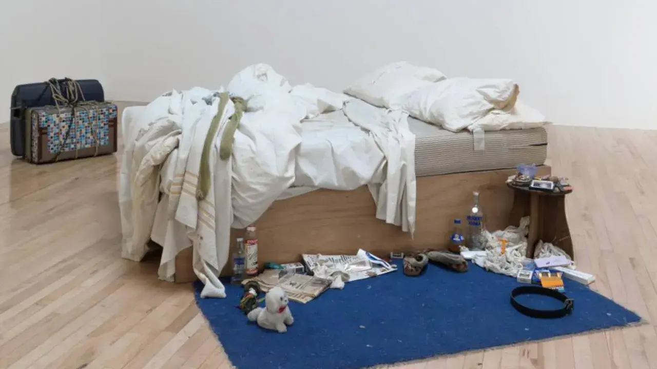 La cama deshecha de Tracey Emin, rodeada de objetos personales, botellas y maletas, evoca una historia de vida.