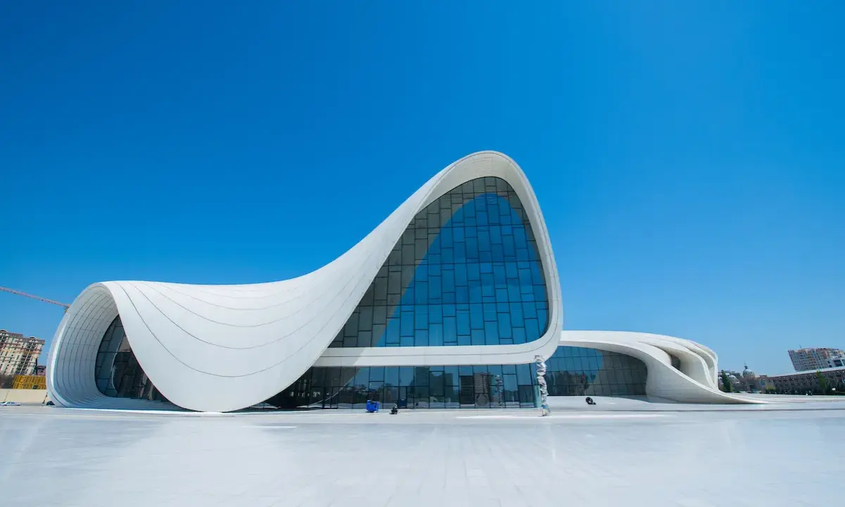Impresionante centro de congresos con fluidas estructuras diseñadas por Zaha Hadid, bajo un cielo azul intenso.