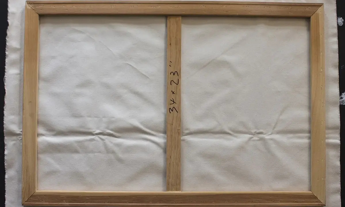 Detalle del reverso de un lienzo de 34x23 pulgadas sobre bastidor de madera, listo para aprender como tensar un lienzo.
