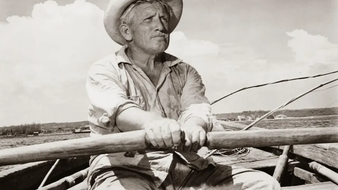 Un viejo pescador con sombrero de paja rema en su bote, evocando el espíritu de "el viejo y el mar resumen".