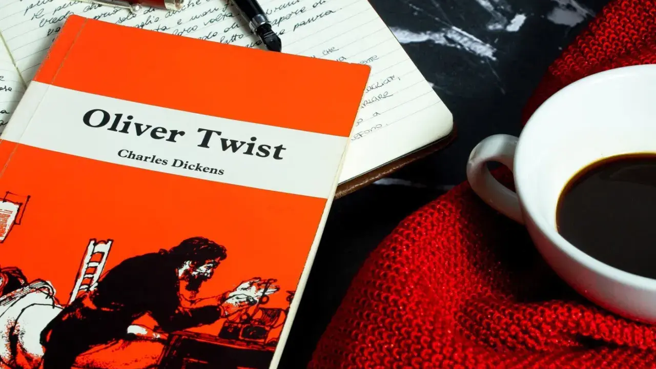 Un libro de "Oliver Twist" y una taza de café, ideal para un resumen de la historia.
