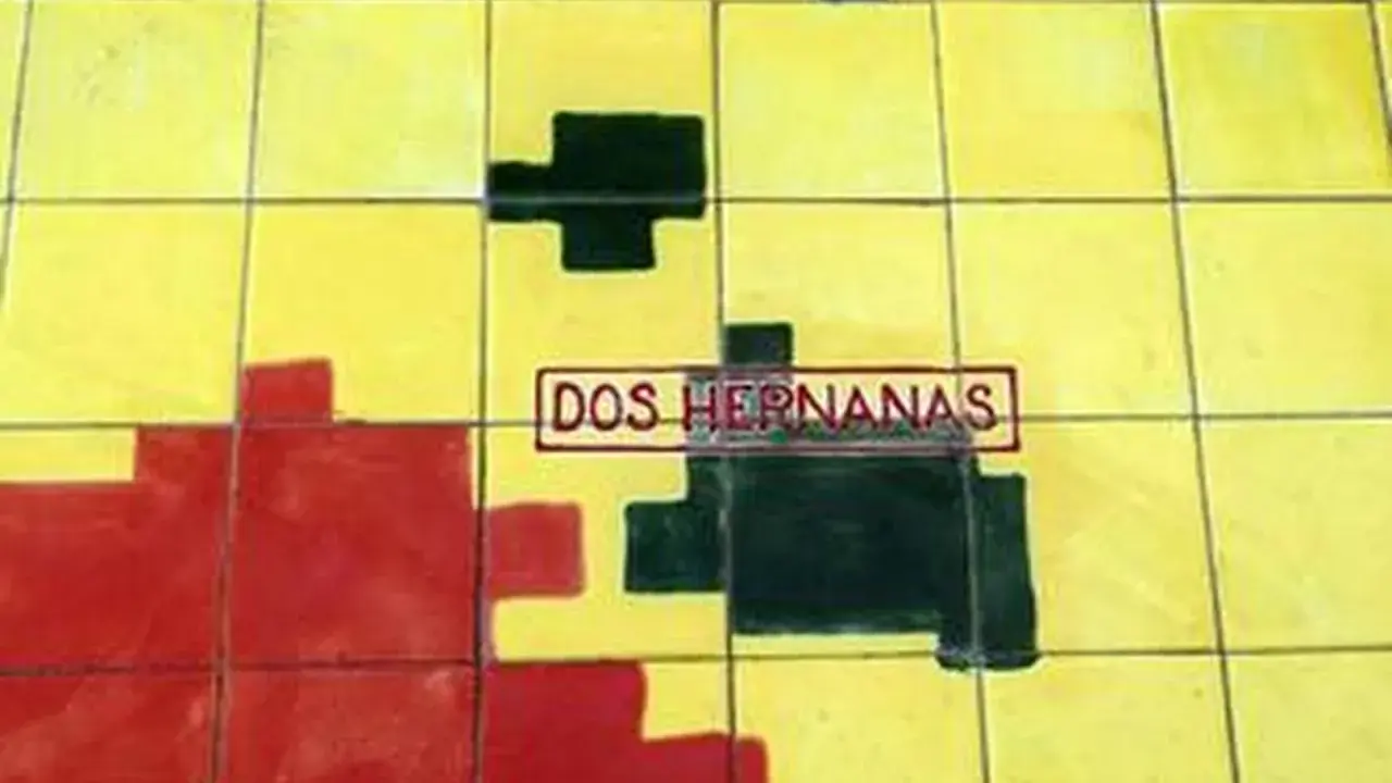 Un mosaico de azulejos amarillos, rojos y negros con el texto "DOS HERNANAS" en un recuadro.