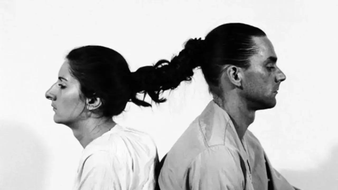Obras de arte de Marina Abramović: mujer y hombre unidos por el pelo, mirándose en direcciones opuestas.