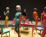 Figuras humanas cubiertas de lunares, parte de las **obras de arte de Yayoi Kusama**, junto a una mesa con objetos decorativos.
