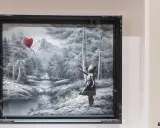 Niña con globo en forma de corazón, en un paisaje nevado con montañas y un río.