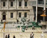 Interior del museo metropolitano de arte de nueva york con esculturas y visitantes.