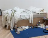La cama deshecha de Tracey Emin, rodeada de objetos personales, botellas y maletas, evoca una historia de vida.