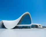 Impresionante centro de congresos con fluidas estructuras diseñadas por Zaha Hadid, bajo un cielo azul intenso.