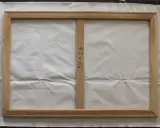 Detalle del reverso de un lienzo de 34x23 pulgadas sobre bastidor de madera, listo para aprender como tensar un lienzo.