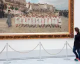 Una mujer observa un cuadro de niños desfilando en los Museos Reales de Bellas Artes de Bélgica.