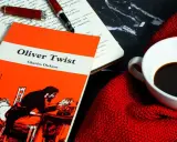 Un libro de "Oliver Twist" y una taza de café, ideal para un resumen de la historia.
