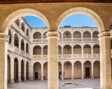 Patio interior con arquerías de varios pisos, columnas y balcones, todo en un elegante estilo renacentista arquitectura.