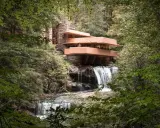 Casa de la Cascada, una obra maestra de las estructuras diseñadas por Frank Lloyd Wright, se alza sobre una cascada en un bosque frondoso.