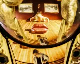 El rostro de Mae West de Dalí, con labios rojos y nariz dorada, se refleja en un espejo curvo.