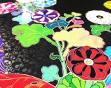 Flores vibrantes y hojas verdes sobre un fondo negro con calaveras, un estilo característico de las obras de Takashi Murakami.