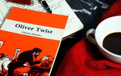 Un libro de "Oliver Twist" y una taza de café, ideal para un resumen de la historia.