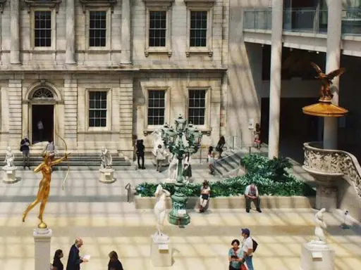 Interior del museo metropolitano de arte de nueva york con esculturas y visitantes.