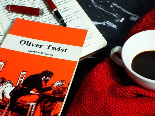 Un libro de "Oliver Twist" y una taza de café, ideal para un resumen de la historia.