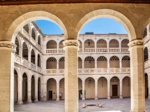 Patio interior con arquerías de varios pisos, columnas y balcones, todo en un elegante estilo renacentista arquitectura.