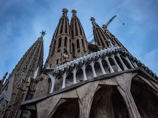 La Sagrada Familia, un espectáculo de arquitectura gótica y moderna, con grúas que sugieren su construcción continua. Un antes y después de una obra maestra.