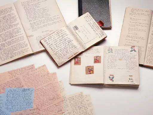Manuscritos y diarios abiertos, como el diario de Ana Frank resumen, con escritura a mano y pequeñas ilustraciones.