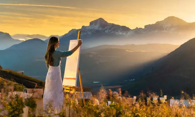 Artista realiza pintura plein air de montañas al atardecer.
