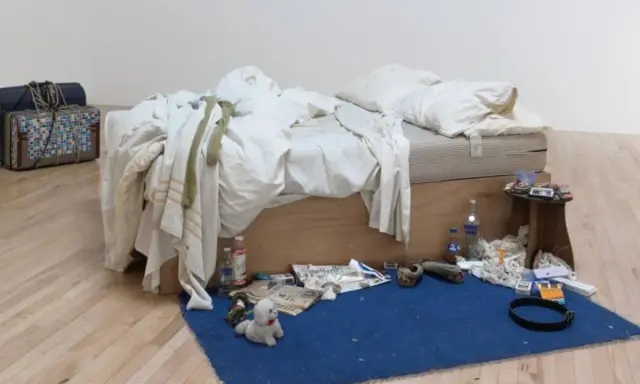 La cama deshecha de Tracey Emin, rodeada de objetos personales, botellas y maletas, evoca una historia de vida.