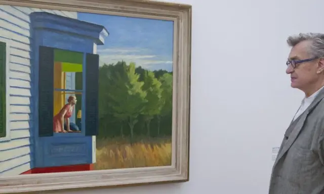 Un hombre contempla "Habitación de hotel" de Edward Hopper, una mujer mira por la ventana de una casa.