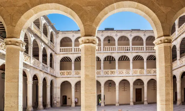 Patio interior con arquerías de varios pisos, columnas y balcones, todo en un elegante estilo renacentista arquitectura.