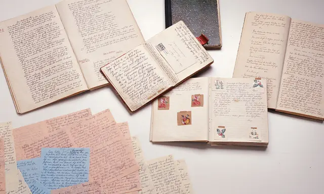 Manuscritos y diarios abiertos, como el diario de Ana Frank resumen, con escritura a mano y pequeñas ilustraciones.