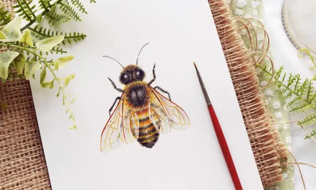 Abeja dibujo realista con detalles en acuarela sobre papel blanco, rodeada de vegetación y un pincel.