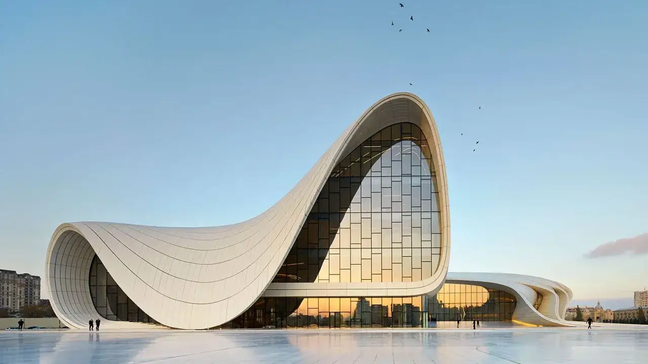 Impresionante edificio con curvas fluidas, un ejemplo de las audaces estructuras dise&ntilde;adas por Zaha Hadid, bajo un cielo azul con p&aacute;jaros volando.