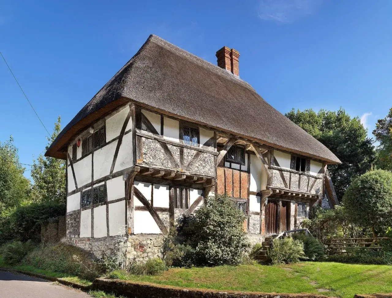 Casa tradicional inglesa con entramado de madera y techo de paja, un ejemplo de los diversos tipos de casas del mundo.