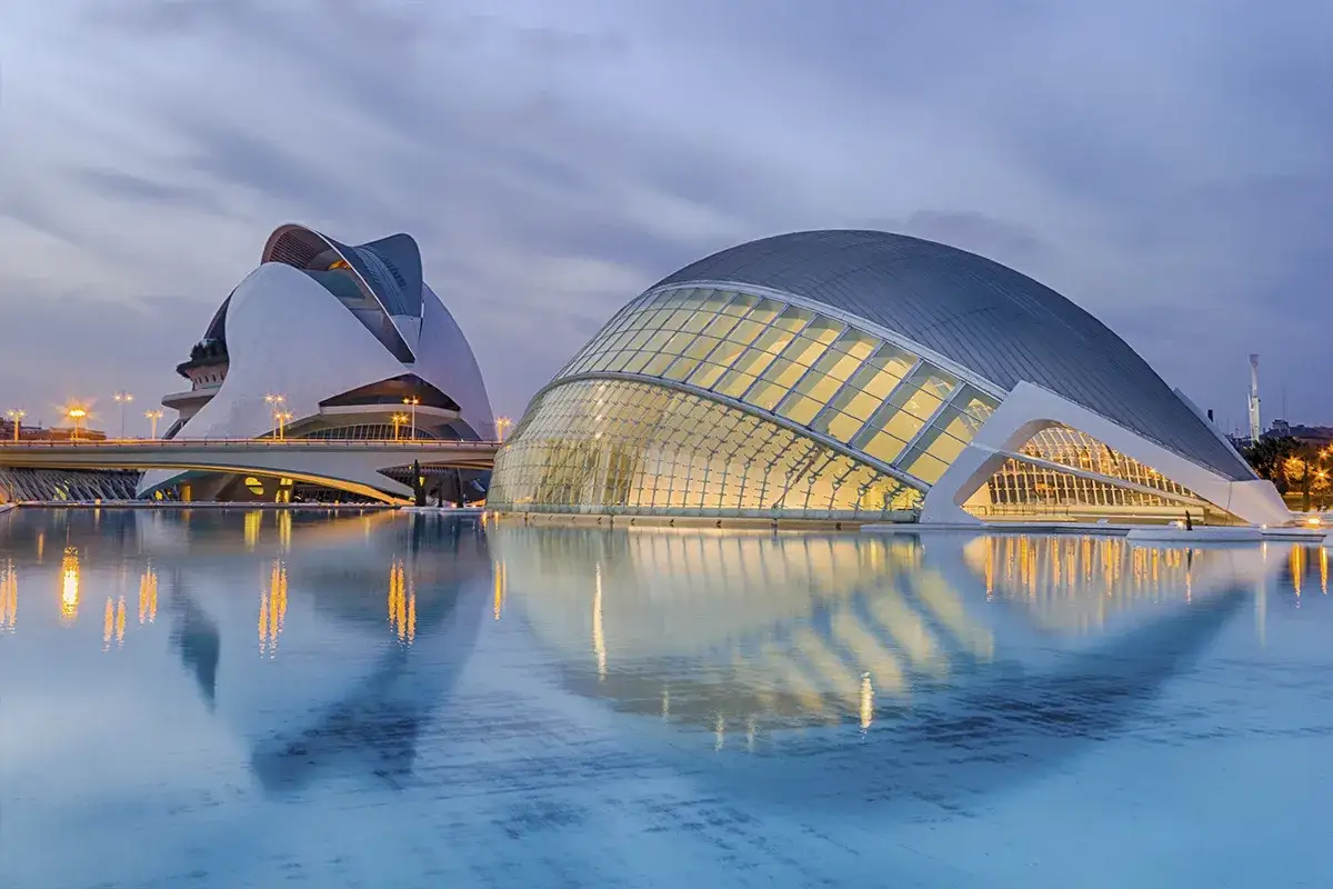 Espectaculares estructuras diseñadas por Santiago Calatrava, reflejadas en el agua al anochecer.
