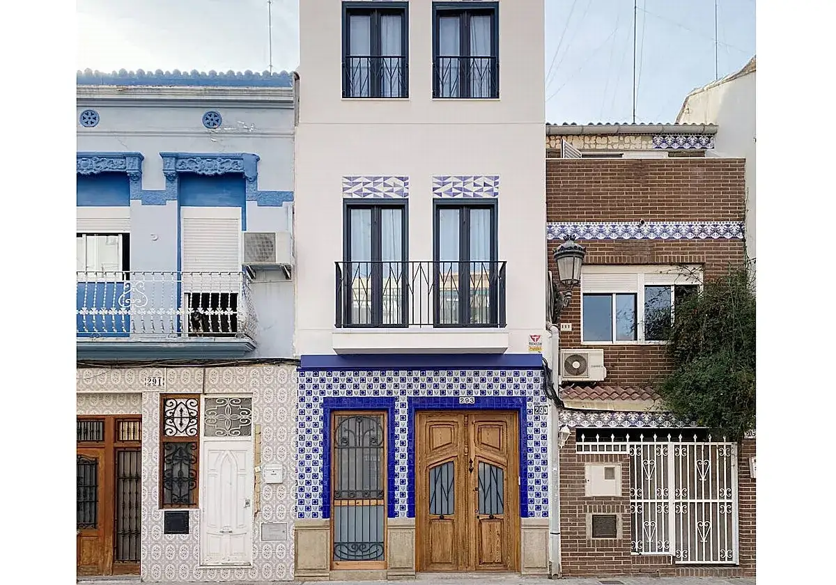 Fachadas de casas con azulejos de estilo art d&eacute;co en tonos azules y blancos, y puertas de madera.