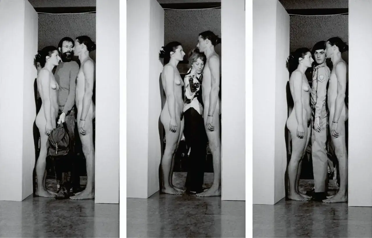 Marina Abramović nude en un performance, rodeada de hombres.