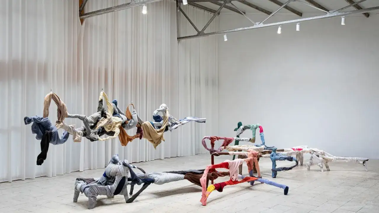 Instalaci&oacute;n de ropa suspendida y en el suelo, un ejemplo de lo que es el arte contempor&aacute;neo, que explora la forma y el color.