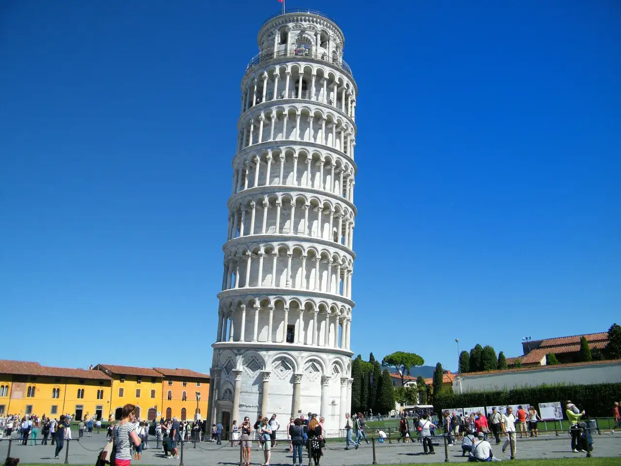 La Torre de Pisa, con su inclinaci&oacute;n &uacute;nica, es un espect&aacute;culo fascinante. Descubre curiosidades de la Torre de Pisa mientras turistas pasean.