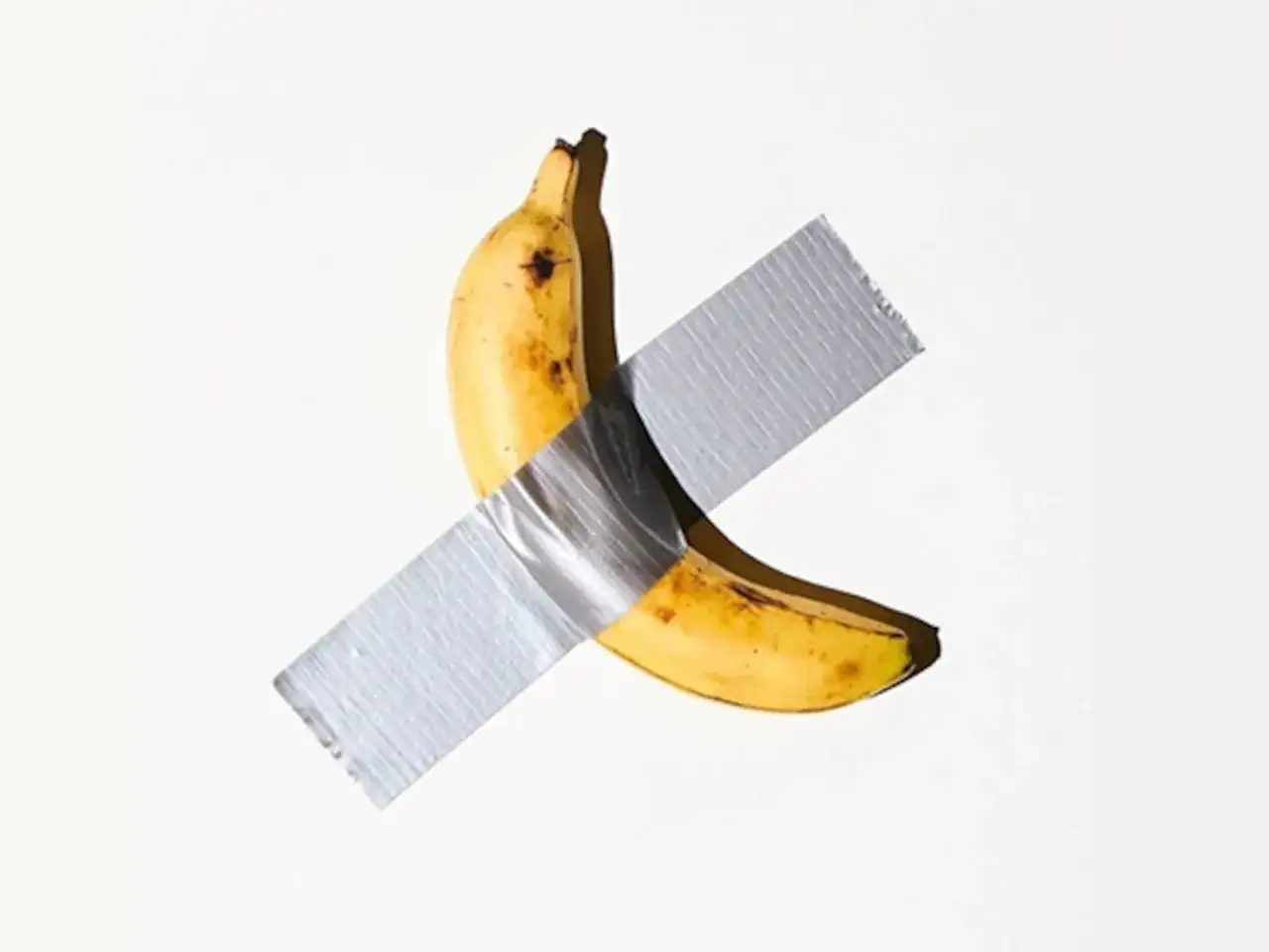 Una obra de arte platano, con cinta plateada cruzada, sobre fondo blanco.